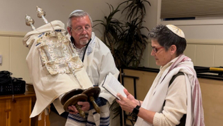 Joe Martin holds the Torah for the first time during his welcoming ceremony, where he was introduced to the congregation as having completed his conversion.