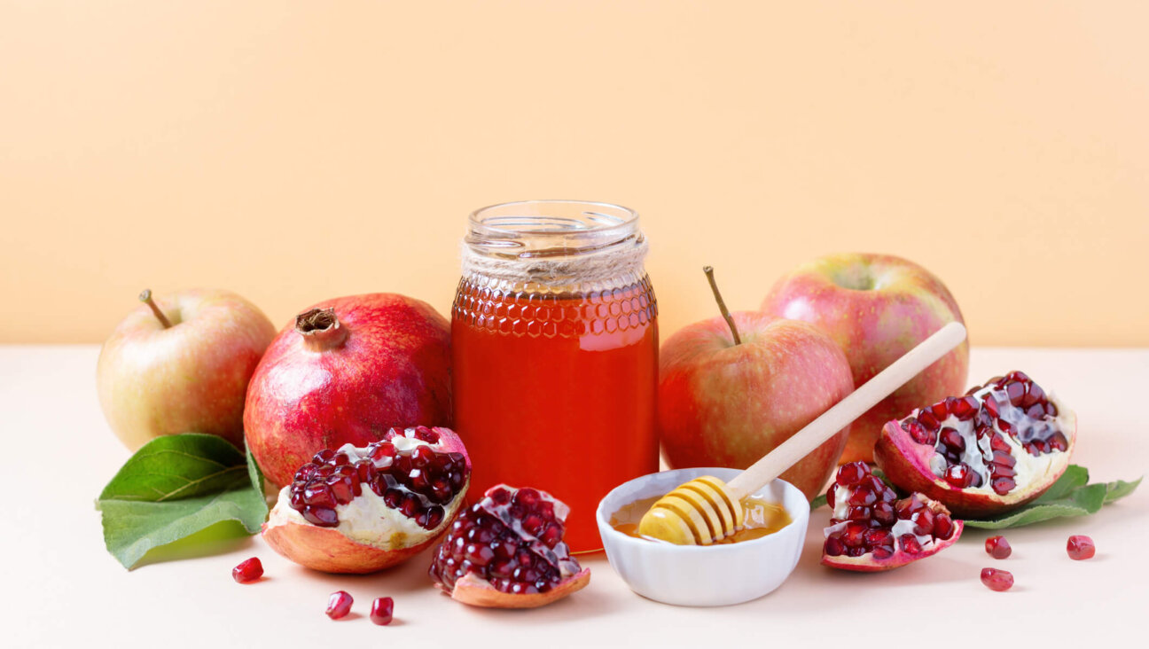 Apples, jar of honey and pomegranates on tray for Jewish holiday Rosh Hashanah on neutral background, copy space