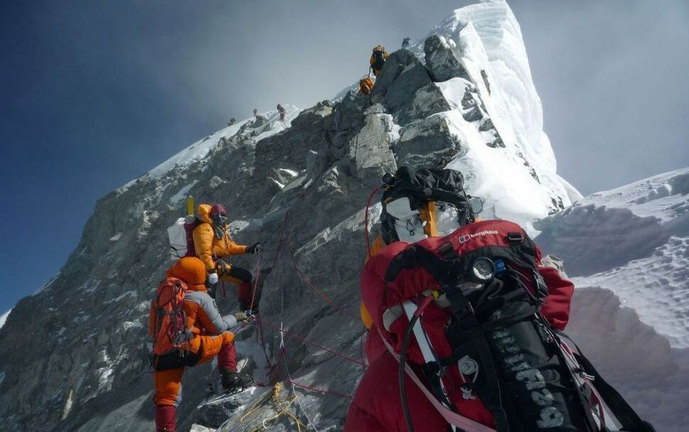 In this photograph taken on May 19, 2009, mountaineers walk past the Hillary Step while pushing for the summit of Mount Everest as they climb the south face of the mountain from Nepal