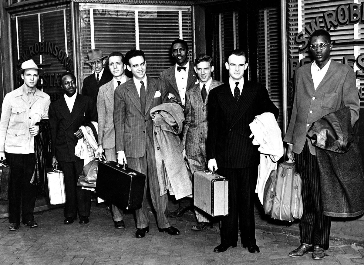Igal Roodenko, fifth from left in striped suit, carrying black suitcase and holding coat, with other members of the Journey of Reconciliation in front of the offices of NAACP lawyer Spottswood Robinson in Richmond, Va., on April 14, 1947. 