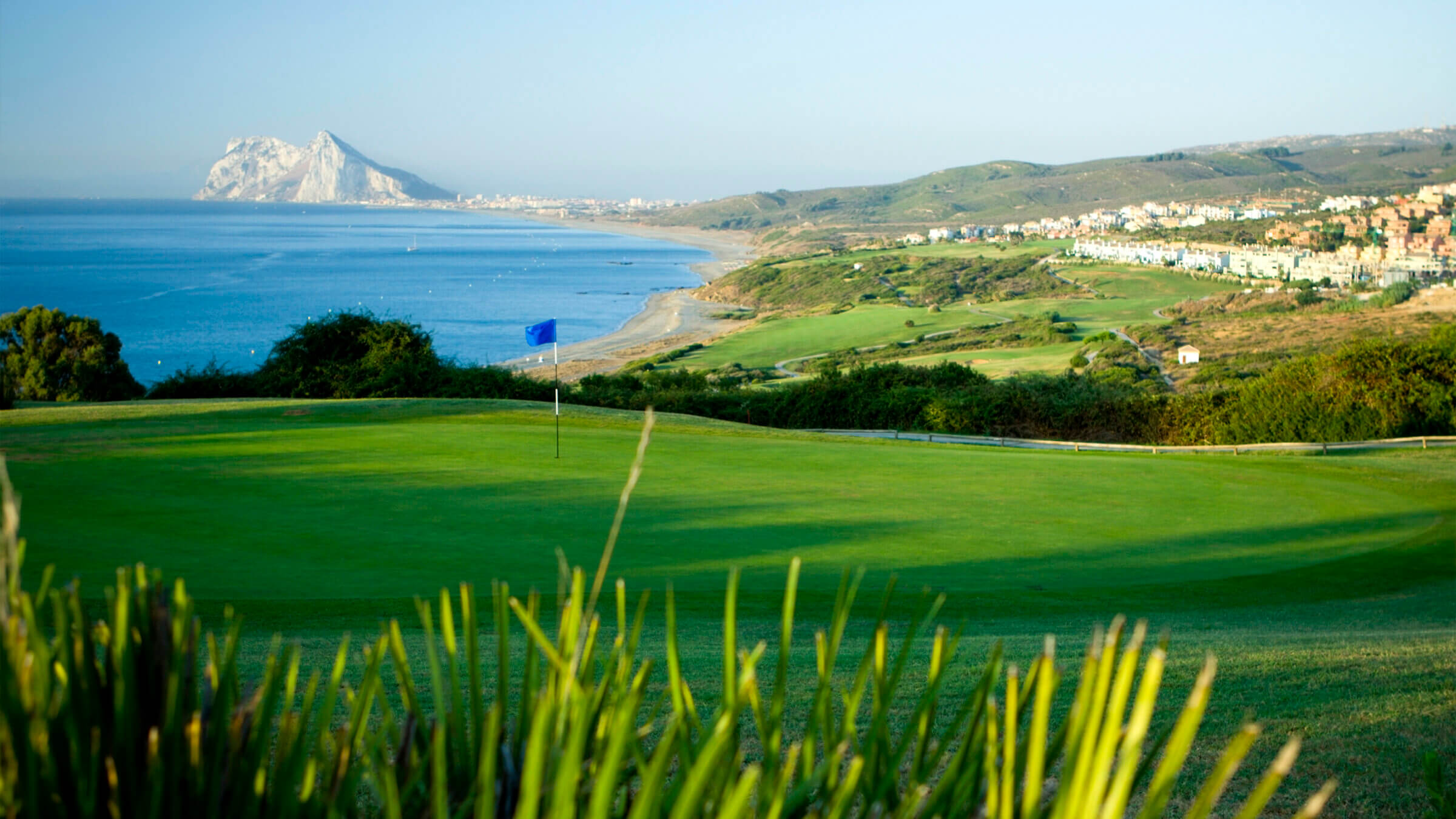 A golf course alone the Southern Coast of Spain with Gibraltar in the distance.