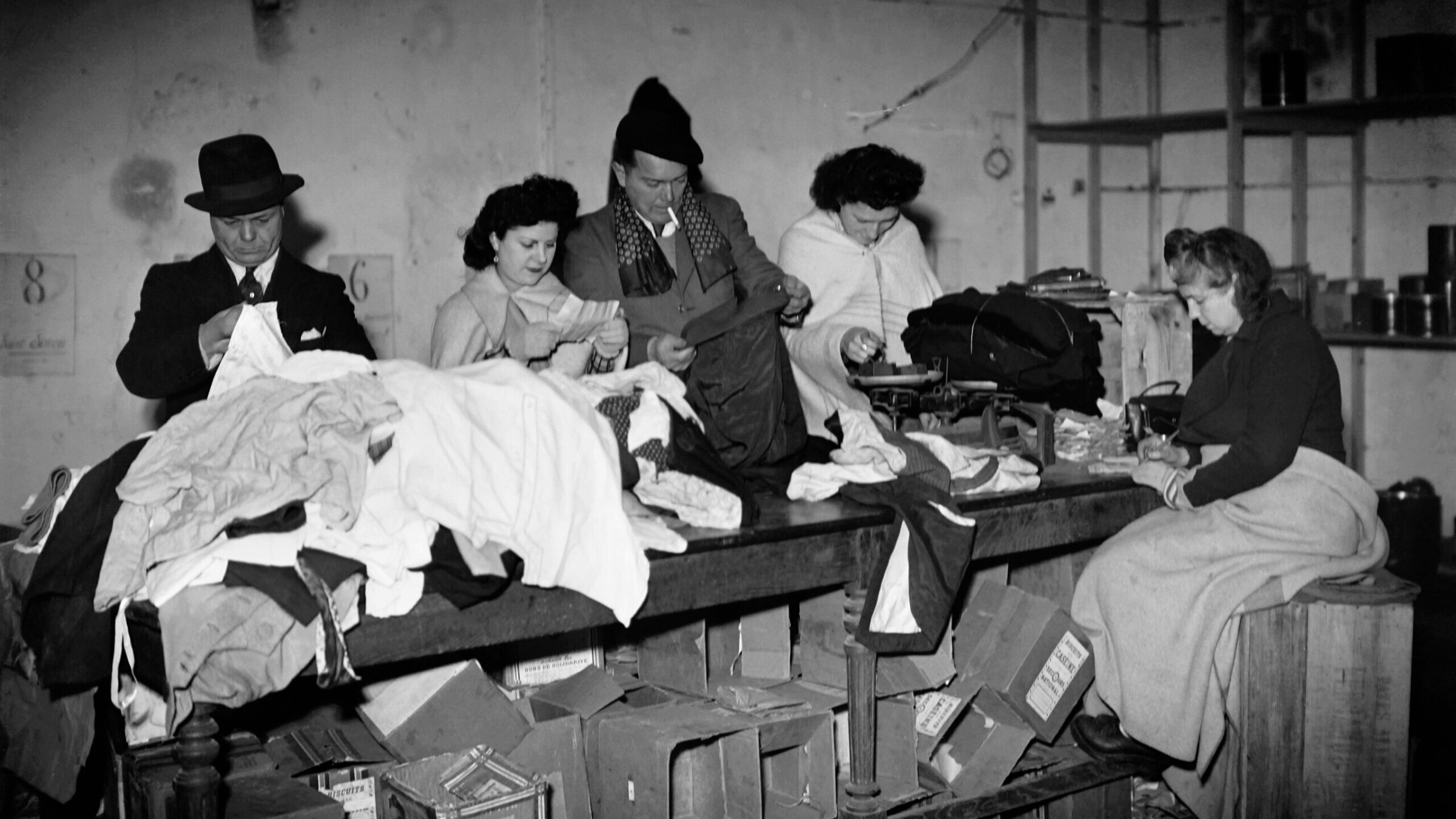 People collect clothes for war victims and homeless in January 1945 in the 20th arrondissement of Paris, during the Second World War. 