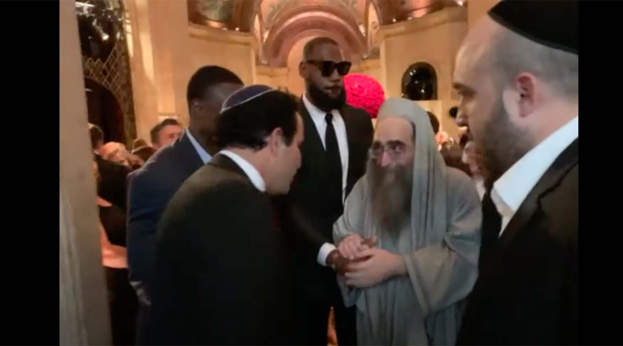 LeBron James holds hands with Rabbi Yoshiyahu Yosef Pinto at the wedding of Jeffrey Schottenstein in New York City, May 22, 2022. (Screenshot from YouTube/Jewish Insider)