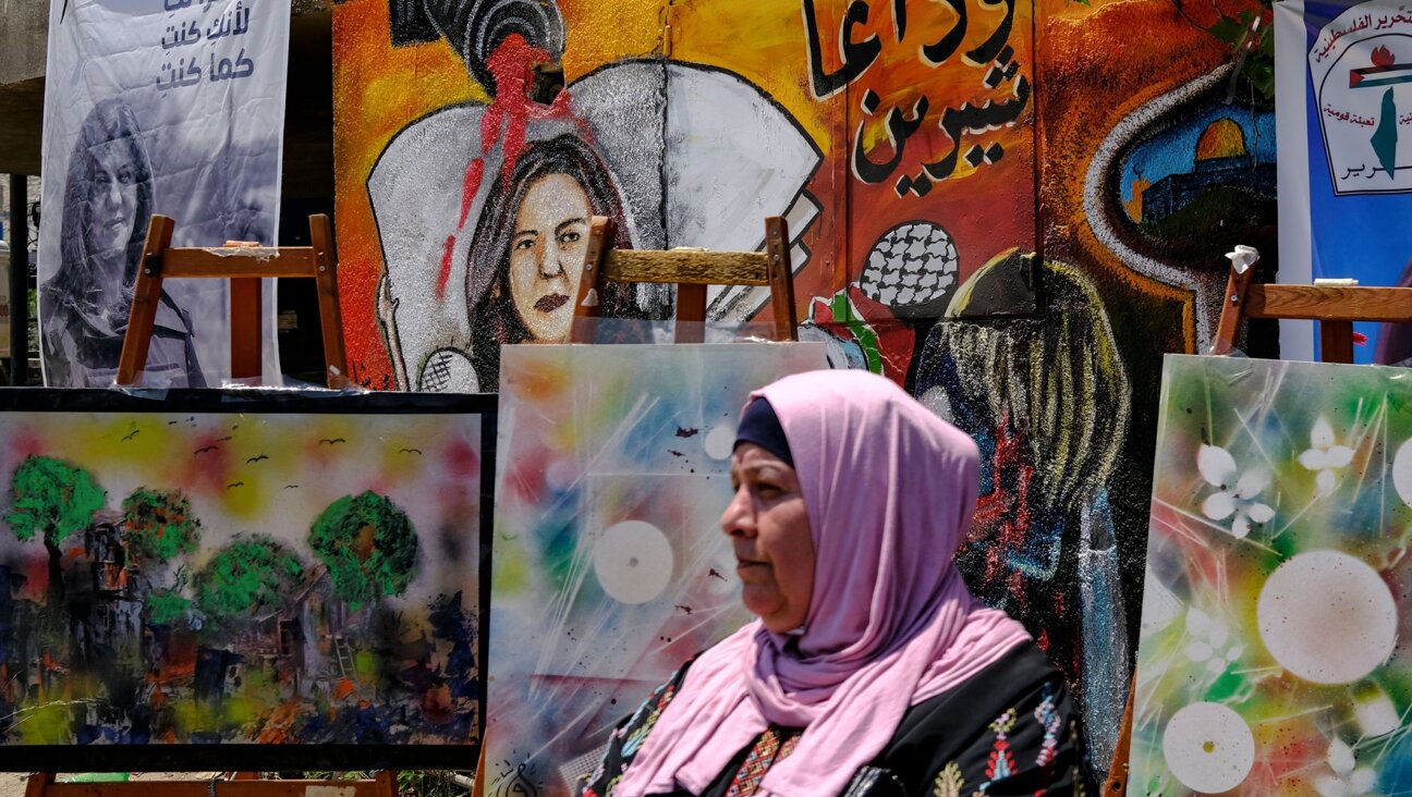 A woman stands in front of a mural, part of an art exhibit honoring slain Palestinian Al-Jazeera journalist Shireen Abu Akleh, at the spot where she was killed in Jenin in the West Bank, May 19, 2022. (Ronaldo Schemidt/AFP via Getty Images)