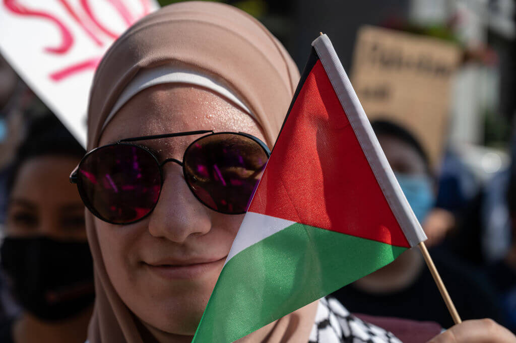 A woman holds the flag of Palestine next to her face during a pro-Palestine protest on the steps of City Hall on May 23, 2021 in Louisville, Kentucky. 