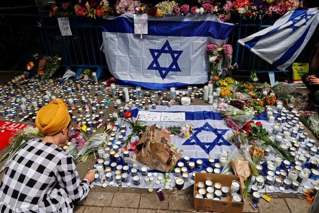 Israelis light candles at the site of a shooting attack the previous night at Dizengoff Street in Tel Aviv on April 8, 2022. 