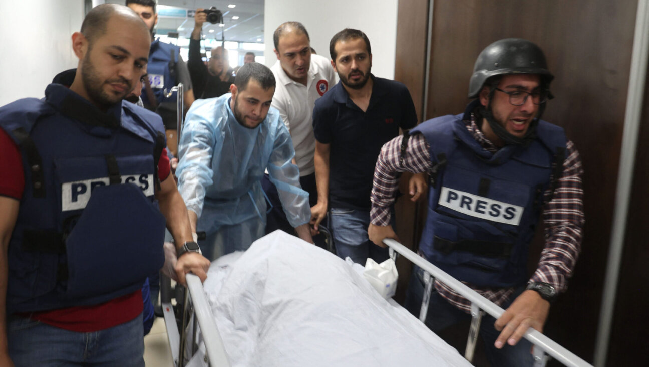 Mujahed al-Saadi, a cameraman for Palestine Today TV, escorts the body of veteran Al-Jazeera reporter Shireen Abu Akleh, who was shot and killed as she covered a raid on the West Bank’s Jenin refugee camp, May 11, 2022, at the hospital in Jenin.(Jaafar Ashtiyeh/AFP via Getty Images)