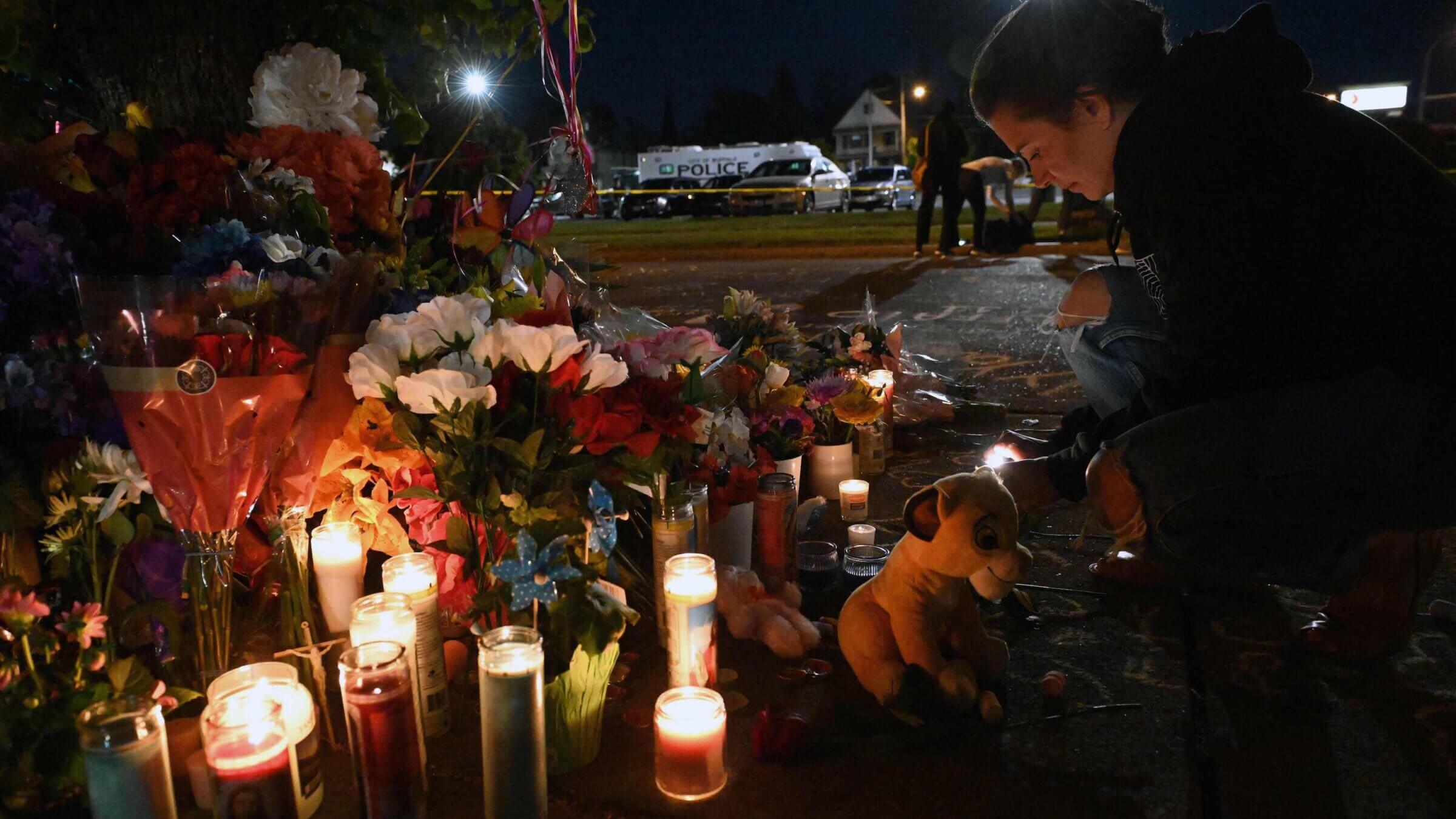 People light candles at a makeshift memorial near a Tops Grocery store in Buffalo, New York, the day after a gunman shot dead 10 people. The alleged shooter appears to have used 4chan, an online forum, to discuss his racist and antisemitic ideology.