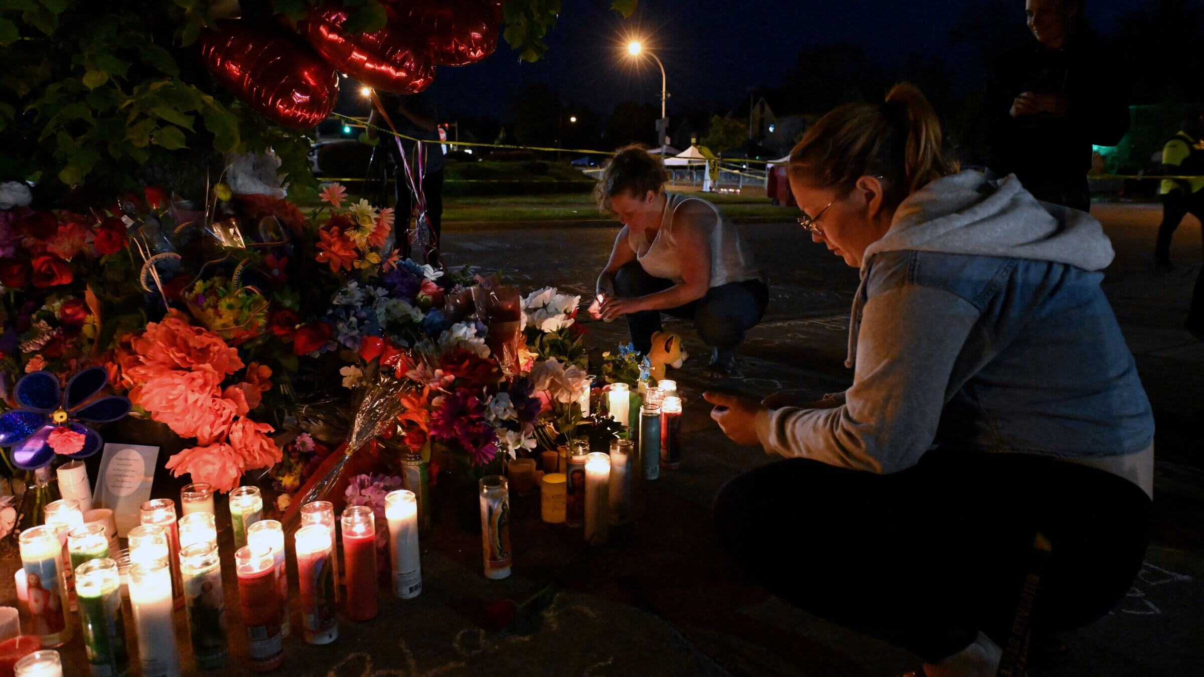 People light candles at a makeshift memorial near a Tops Grocery store in Buffalo.