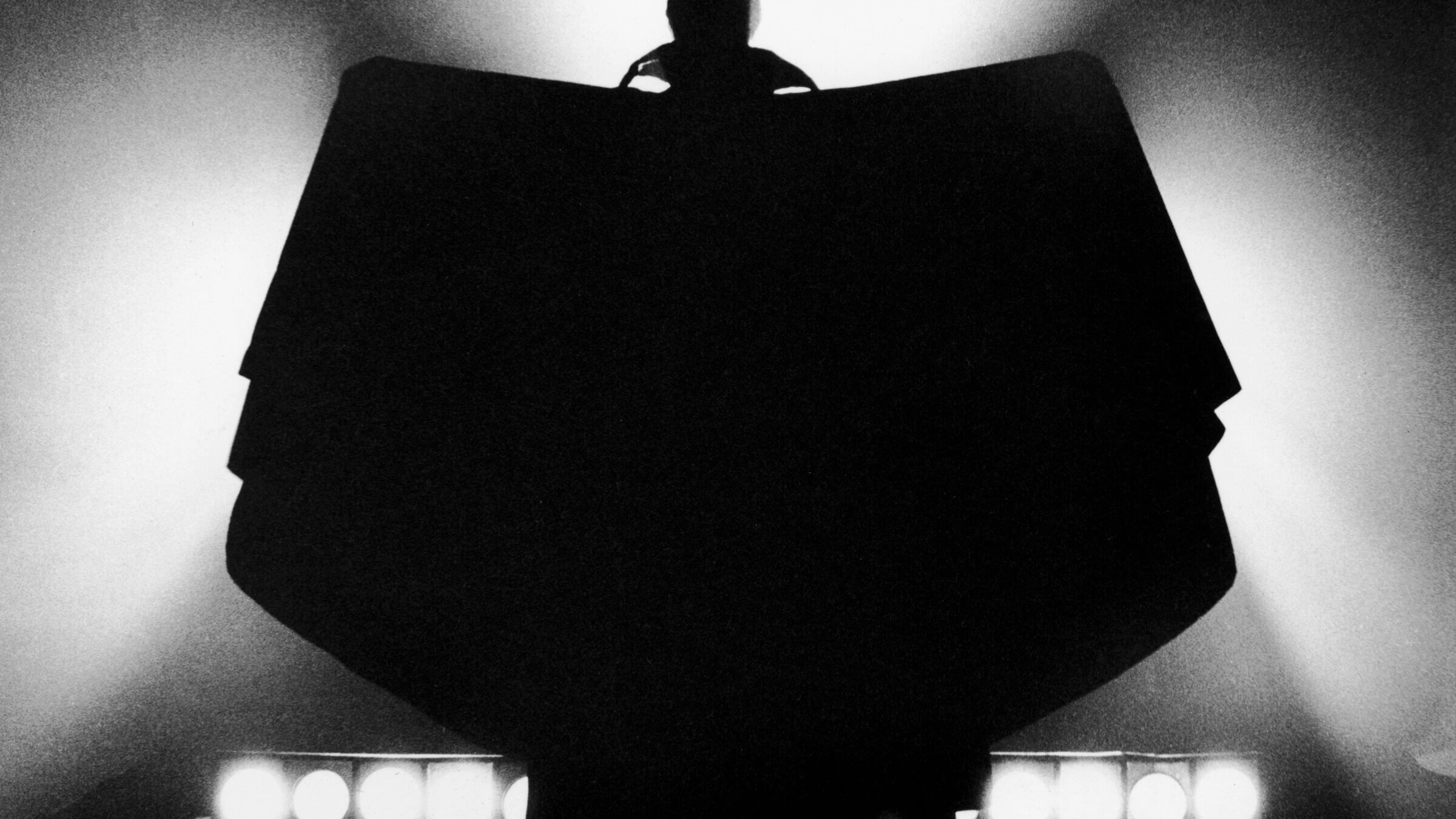 The silhouetted figure of the vampire Count Dracula, raises his cape in batlike-fashion, circa 1970.