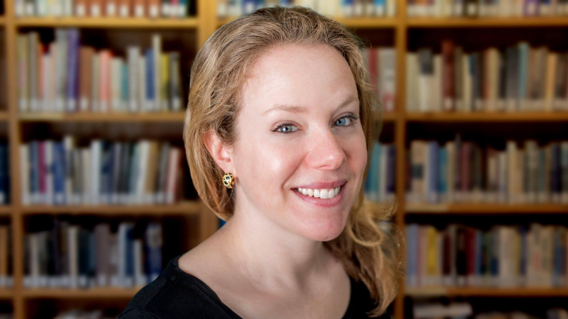 Rachel Barenbaum portrait photo in front of a bookshelf