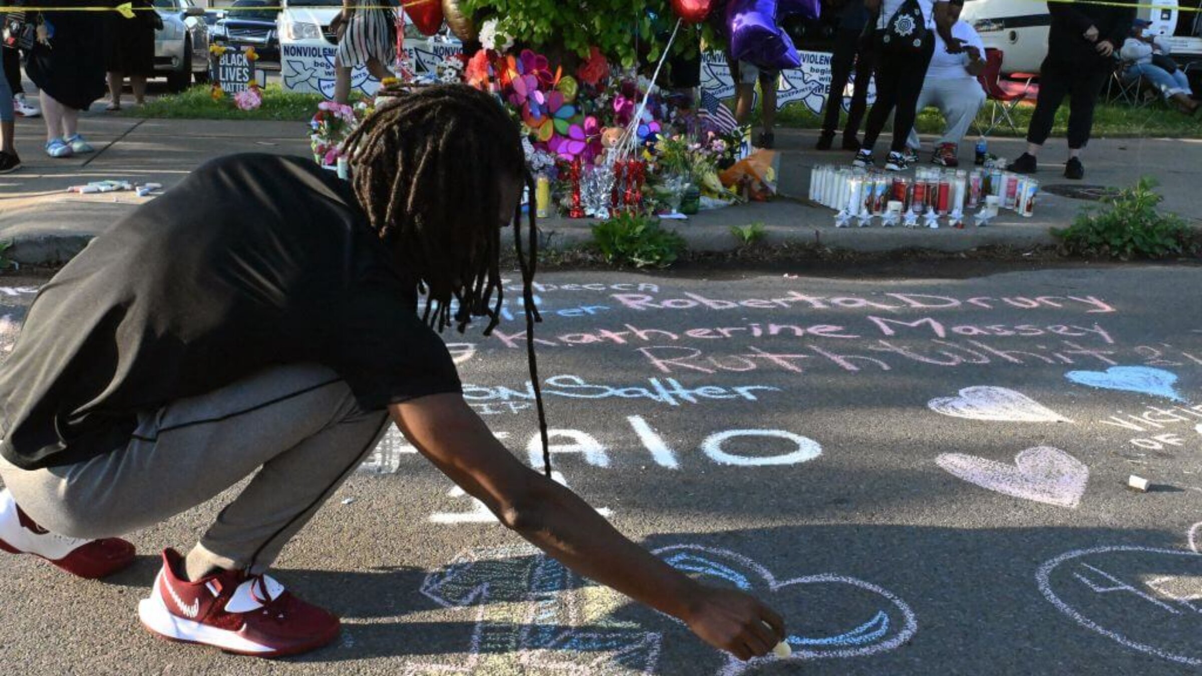People leave messages at a makeshift memorial near a Tops Grocery store in Buffalo, New York, on May 15, 2022, the day after a gunman shot dead 10 people. 