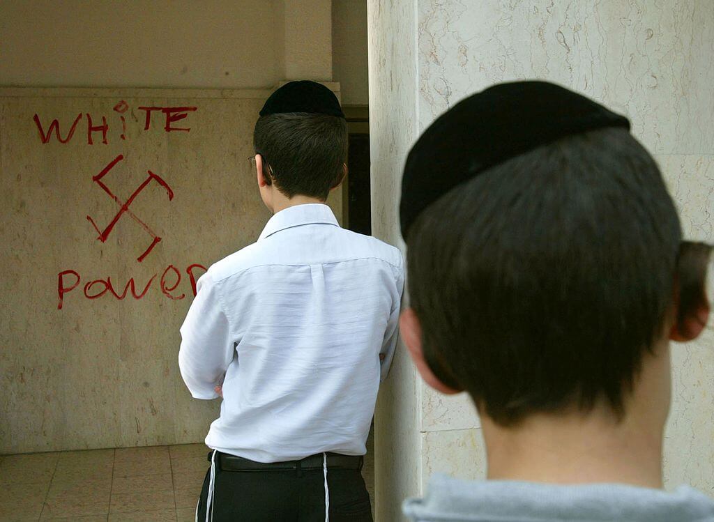 Jewish boys look at anti-semitic graffiti which was sprayed on the walls of a synagogue March 5, 2006 in Petah Tikva, near Tel Aviv, in central Israel. 