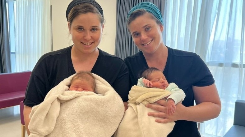 Identical twins Yael Yishai, right, and Avital Segel, left, pose with their newborn sons at Shaare Zedek hospital in Jerusalem, May 30, 2022. (Shaare Zedek)