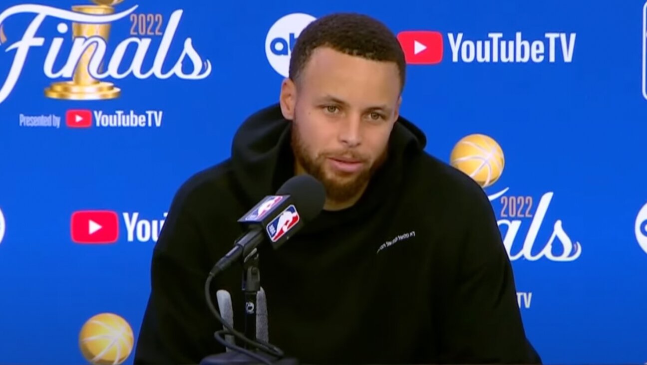 Stephen Curry sporting a sweatshirt with Hebrew on it during an NBA Finals postgame press conference, June 10, 2022. (Screenshot from YouTube)