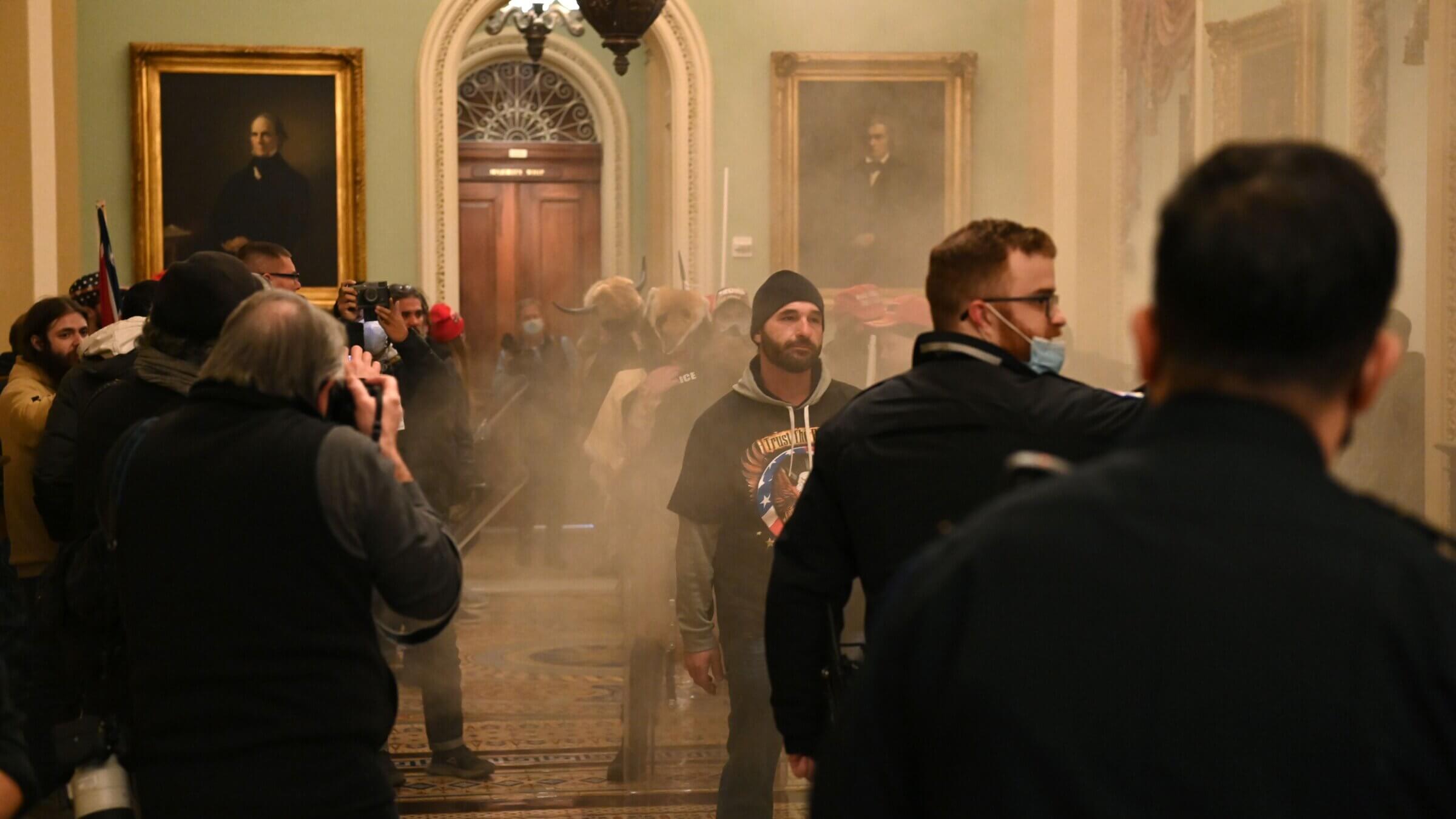 Supporters of President Donald Trump enter the US Capitol as smoke fills the corridor on January 6, 2021