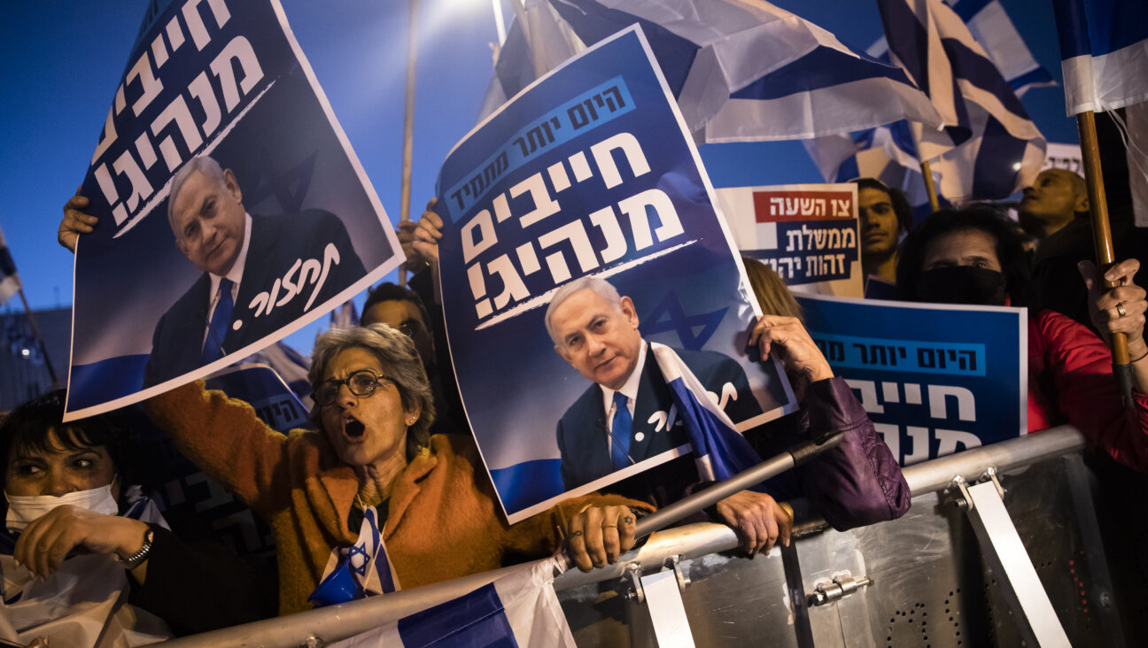 Protestors hold signs reading, "now more than ever, a leader is needed!"  in Hebrew as they protest against the Israeli government on April 6, 2022 in Jerusalem.