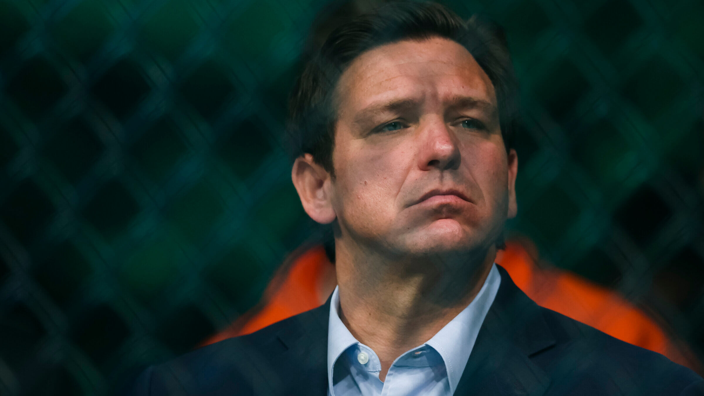 Ron Desantis is seen standing behind a fence