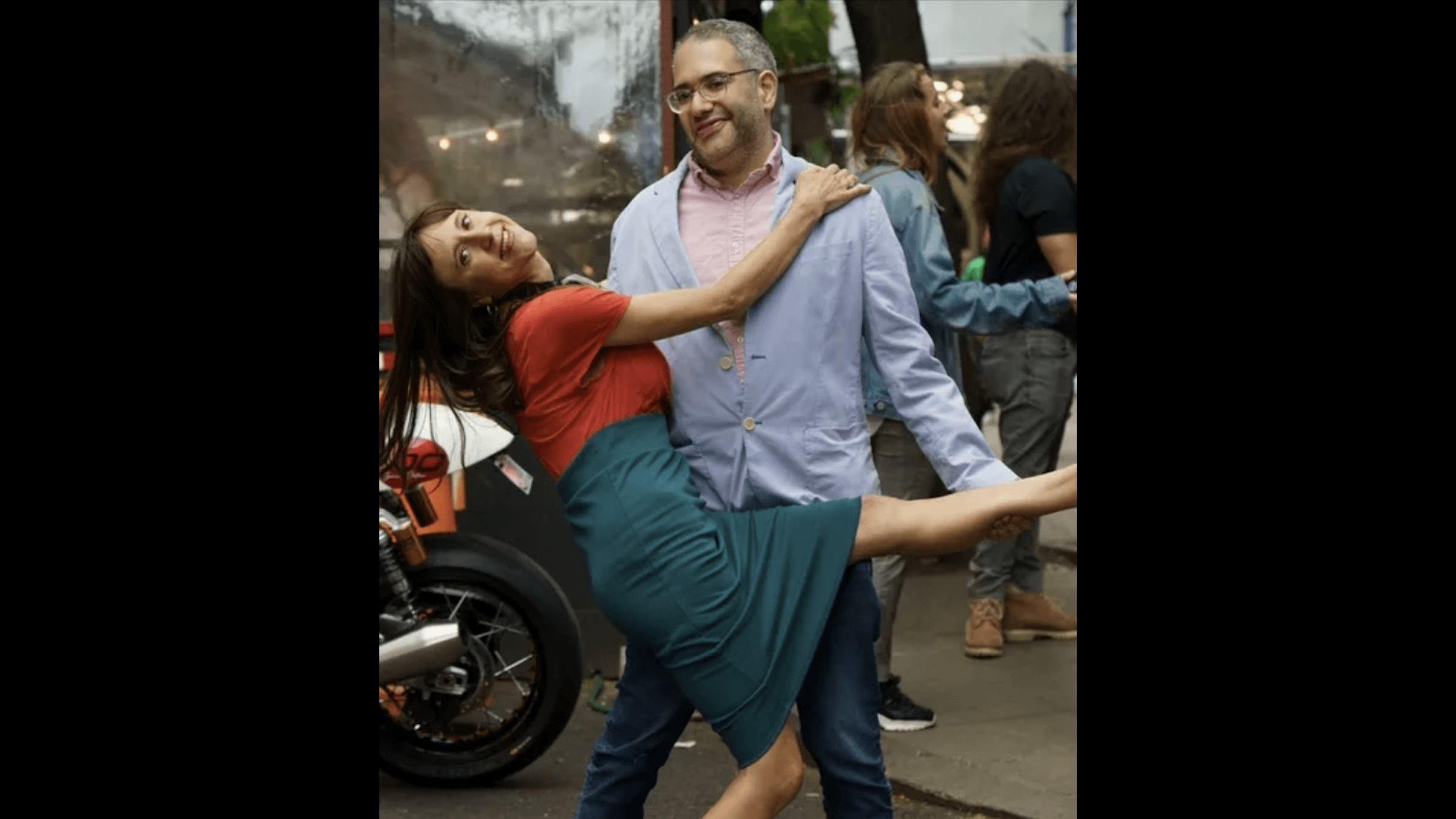 Woman and man embrace in joyful, playful pose