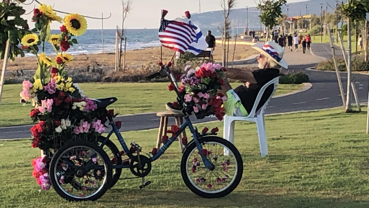 Elderly man on adult tricycle with American flags