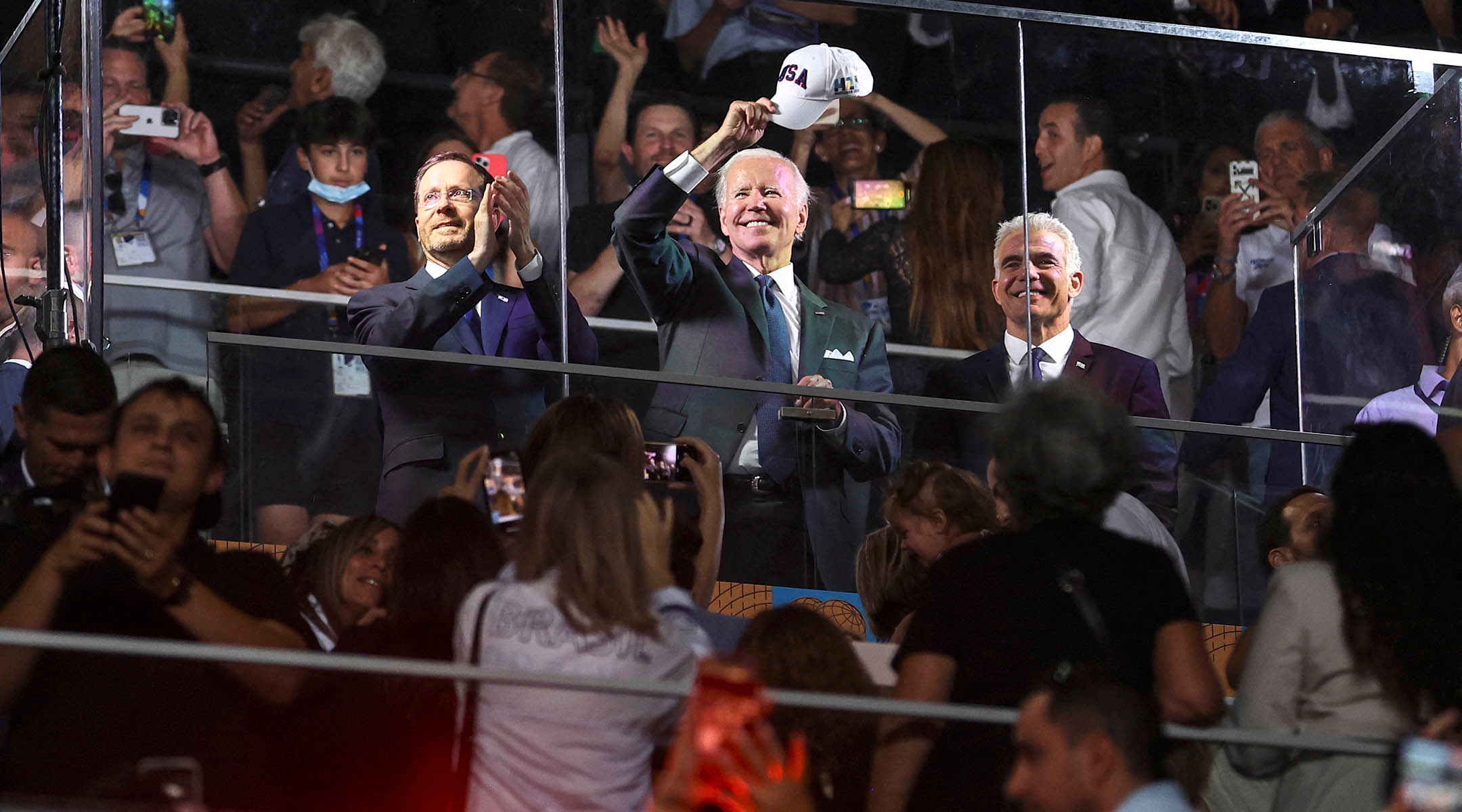 Israeli President Isaac Herzog, President Joe Biden, and Israel’s caretaker Prime Minister Yair Lapid applaud and cheer as they attend the opening ceremony of the Maccabiah Games at Teddy Stadium in Jerusalem, July 14, 2022. (Ronen Zvulun/POOL/AFP via Getty Images)