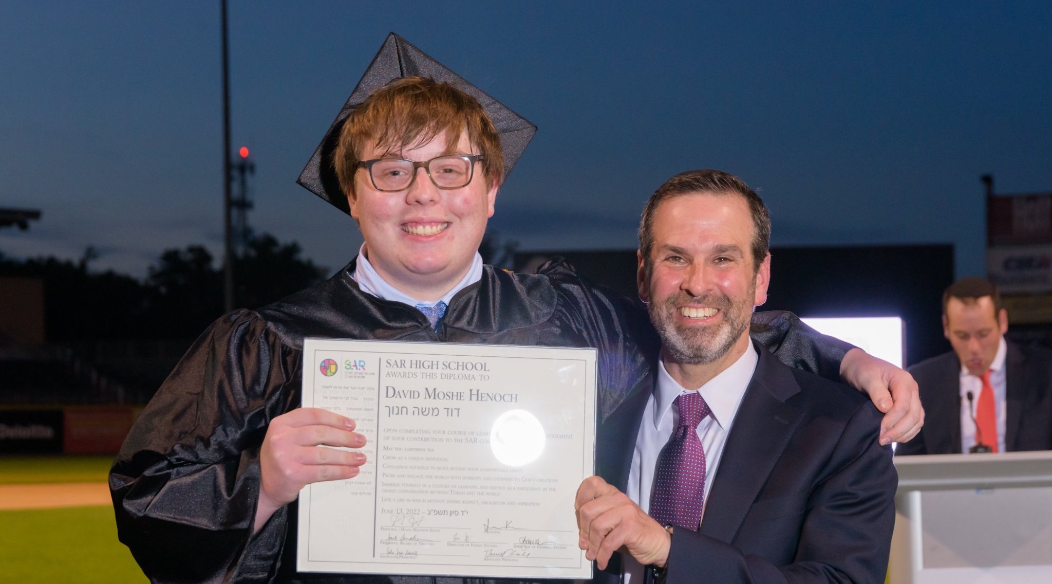 Divi Henoch, shown with Rabbi Rabbi Jonathan Kroll, a principal at SAR High School, on his graduation day, June 13, 2022. (Courtesy SAR High School Facebook)