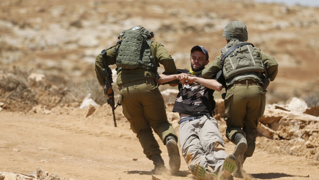 Israeli forces remove a demonstrator during a demonstration by Palestinians and international activists on July 1, 2022, in the Al-Jawaya in Masafer Yatta.