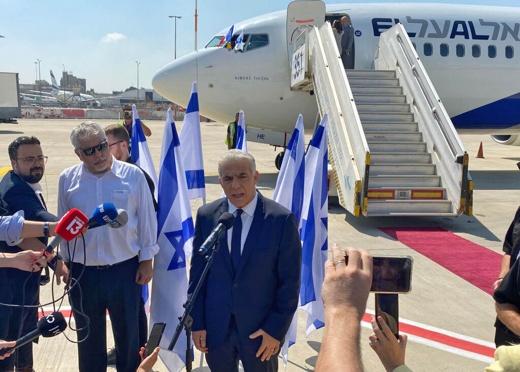 Israel's Prime Minister Yair Lapid speaks to the press ahead of boarding his flight to France on July 5, 2022.