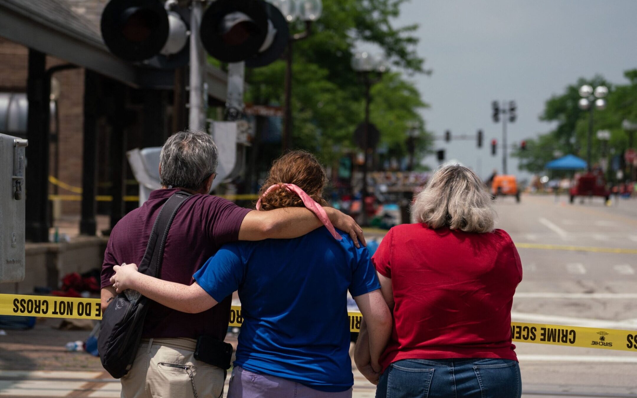 A family embraces while observing the scene of a mass shooting at a July 4th parade in downtown Highland Park, Illinois, July 5, 2022.