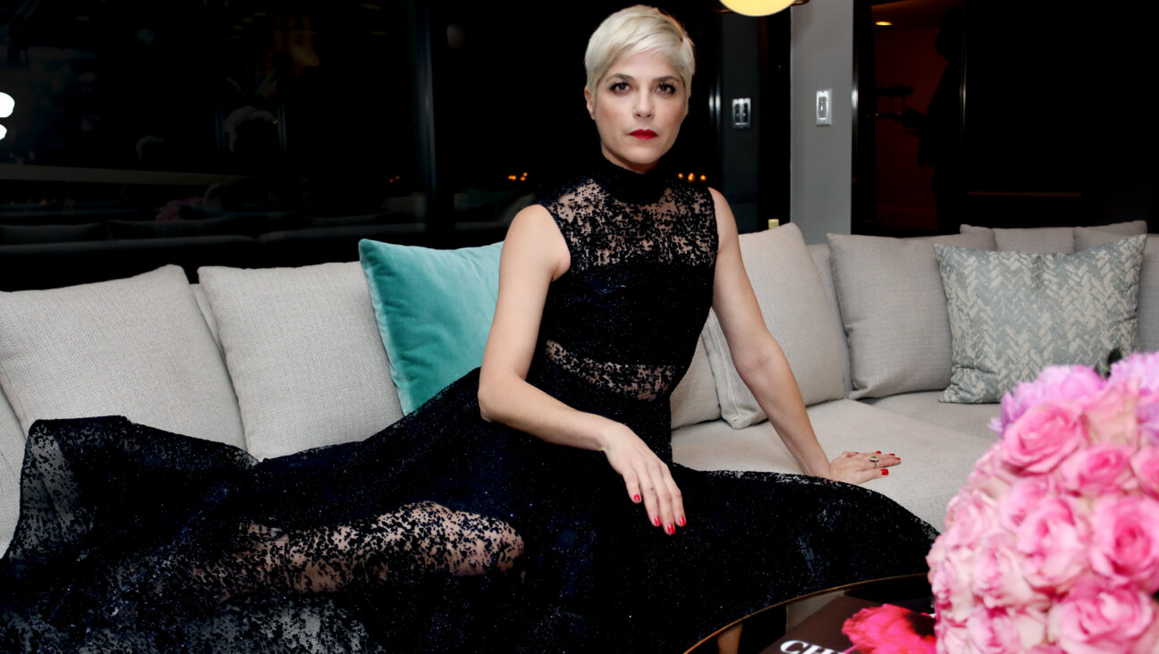 Actress Selma Blair seated on sofa in black gown