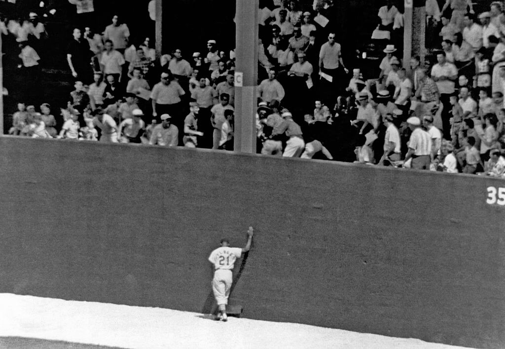 St Louis Cardinal outfielder, Curt Flood, leans against the wall as he symbolizes the frustration of the Cardinals as the fans scramble to get a Phillies home run ball, St. Louis, Aug. 12, 1962.
