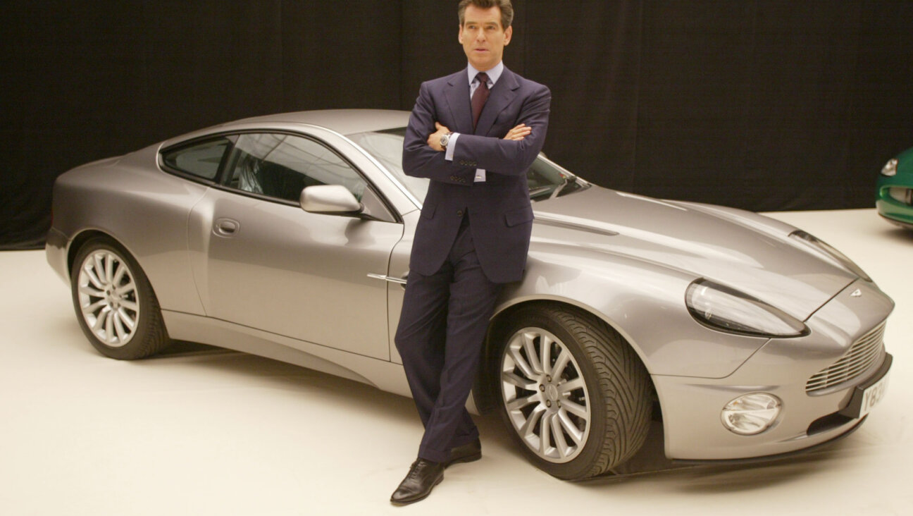Onetime James Bond actor Pierce Brosnan poses with an Aston Martin to promote the film "Die Another Day."