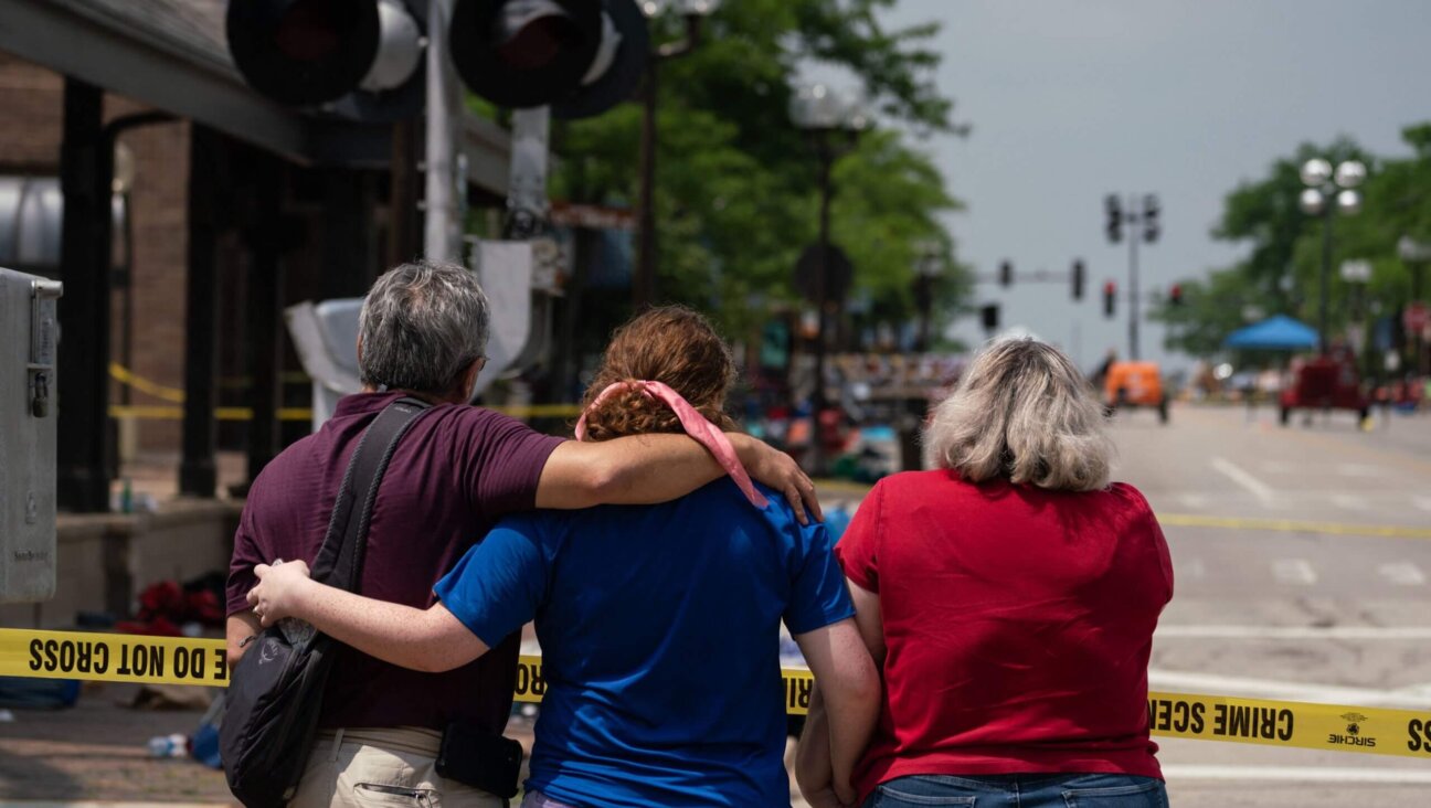 A family embraces each other the day of a mass shooting at a July 4th parade in downtown Highland Park, Illinois.