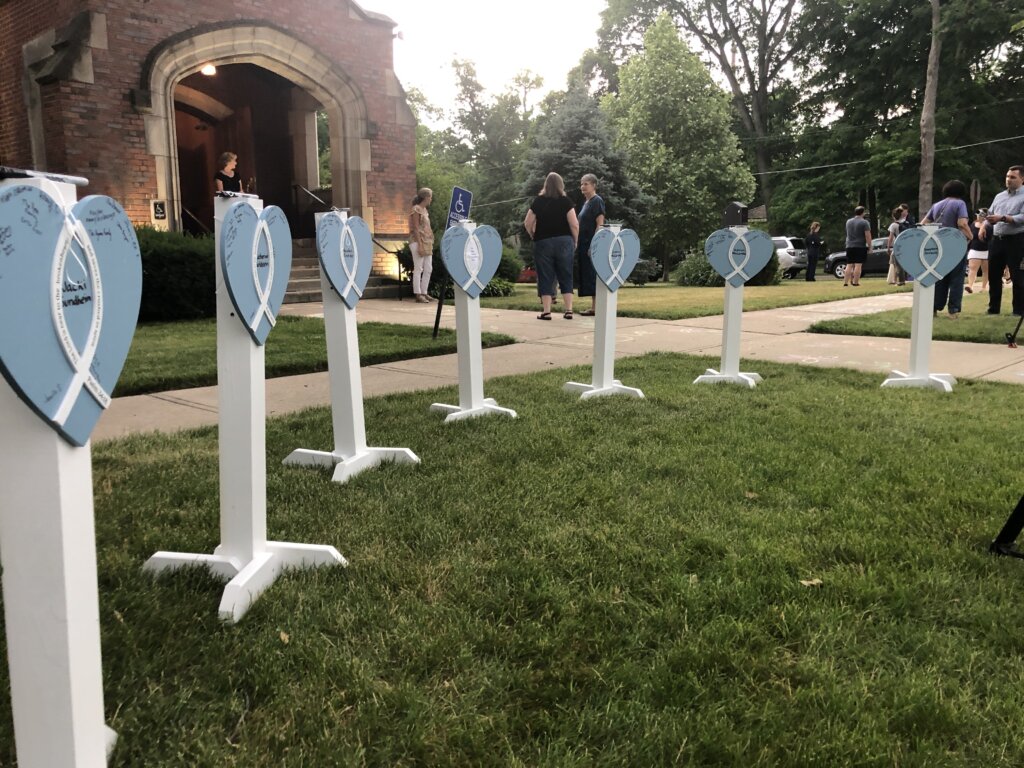Memorials for Jacki Sundheim (left) and the other victims of the July 4 shootings outside the Highland Park Presbyterian Church at a inter-religious vigil.