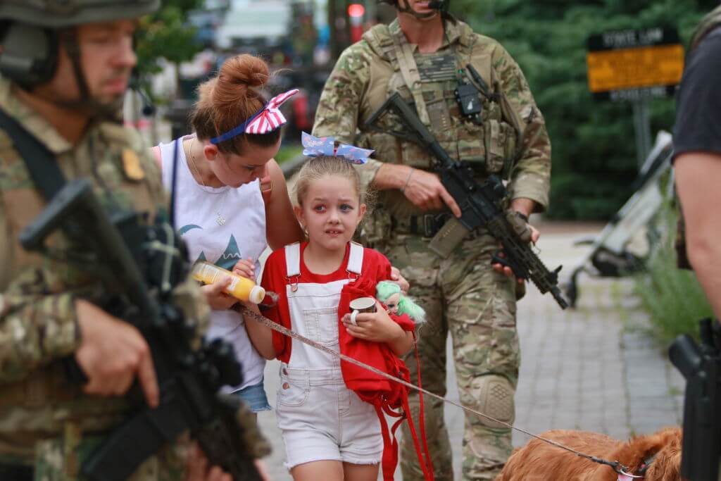 Law enforcement escorts a family away from the scene of a shooting at a Fourth of July parade on July 4, 2022 in Highland Park, Illinois. 