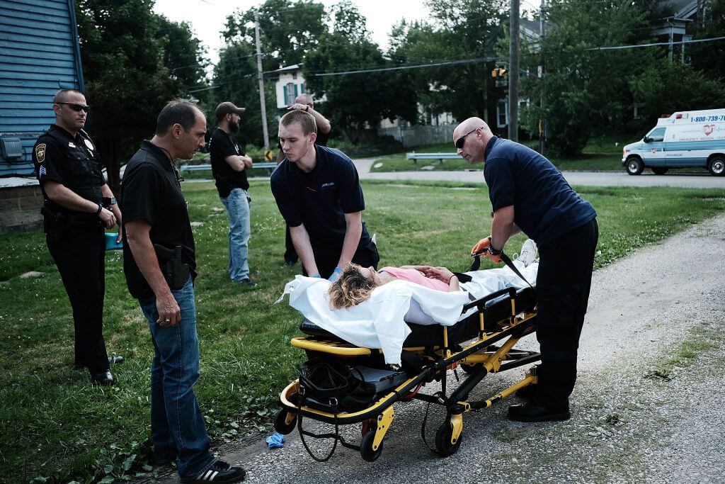 Medical workers and police treat a woman who has overdosed on heroin, the second case in a matter of minutes,  on July 14, 2017 in Warren, Ohio. 