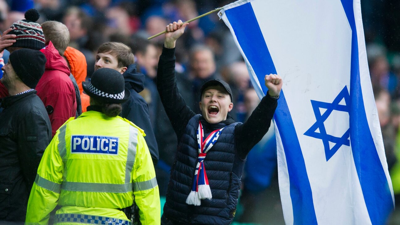 A Rangers FC fan celebrates while holding an Israeli flag during a match against Celtic FC in 2017. (Ross MacDonald/SNS Group via Getty Images)