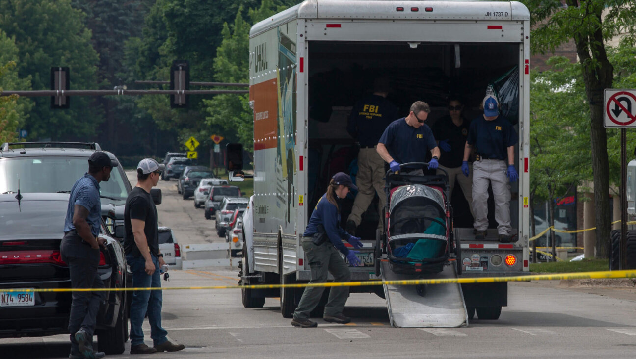 FBI agents clear abandoned strollers near the scene of the shooting at a Fourth of July parade in Highland Park, Illinois.