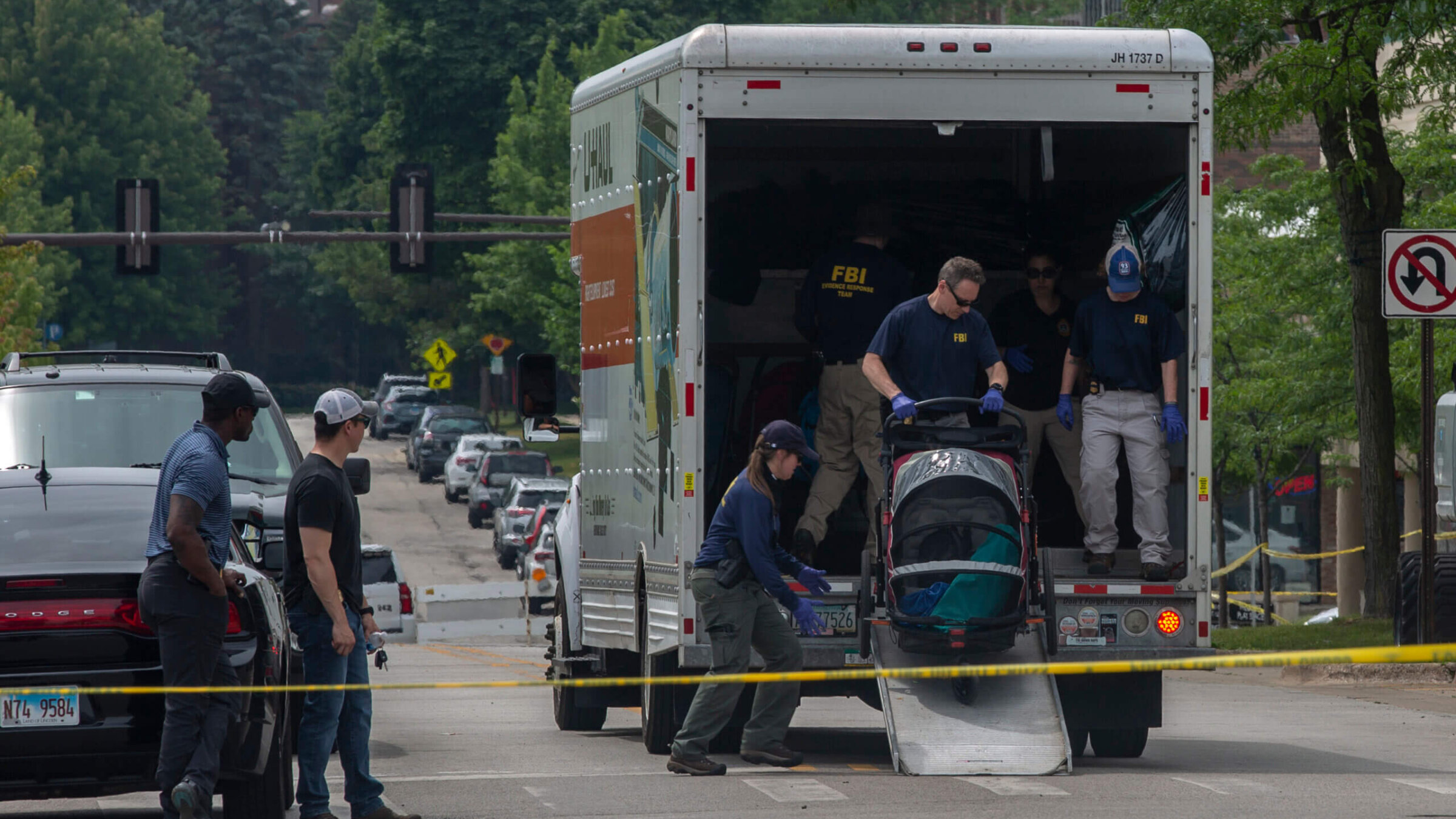 FBI agents clear abandoned strollers near the scene of the shooting at a Fourth of July parade in Highland Park, Illinois.