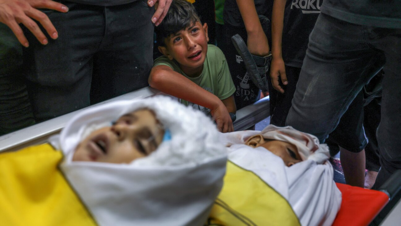 A boy cries by the bodies of four Palestinians from the Najm family during their funeral in Jabalia in the northern Gaza Strip on Aug. 8, 2022, after they were killed during the latest three days of conflict between Israel and Palestinian militants before a ceasefire