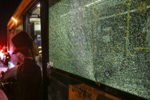 An ultra-Orthodox Jewish man looks at a bullet impact on a bus window after an attack outside Jerusalem's Old City, August 14, 2022.