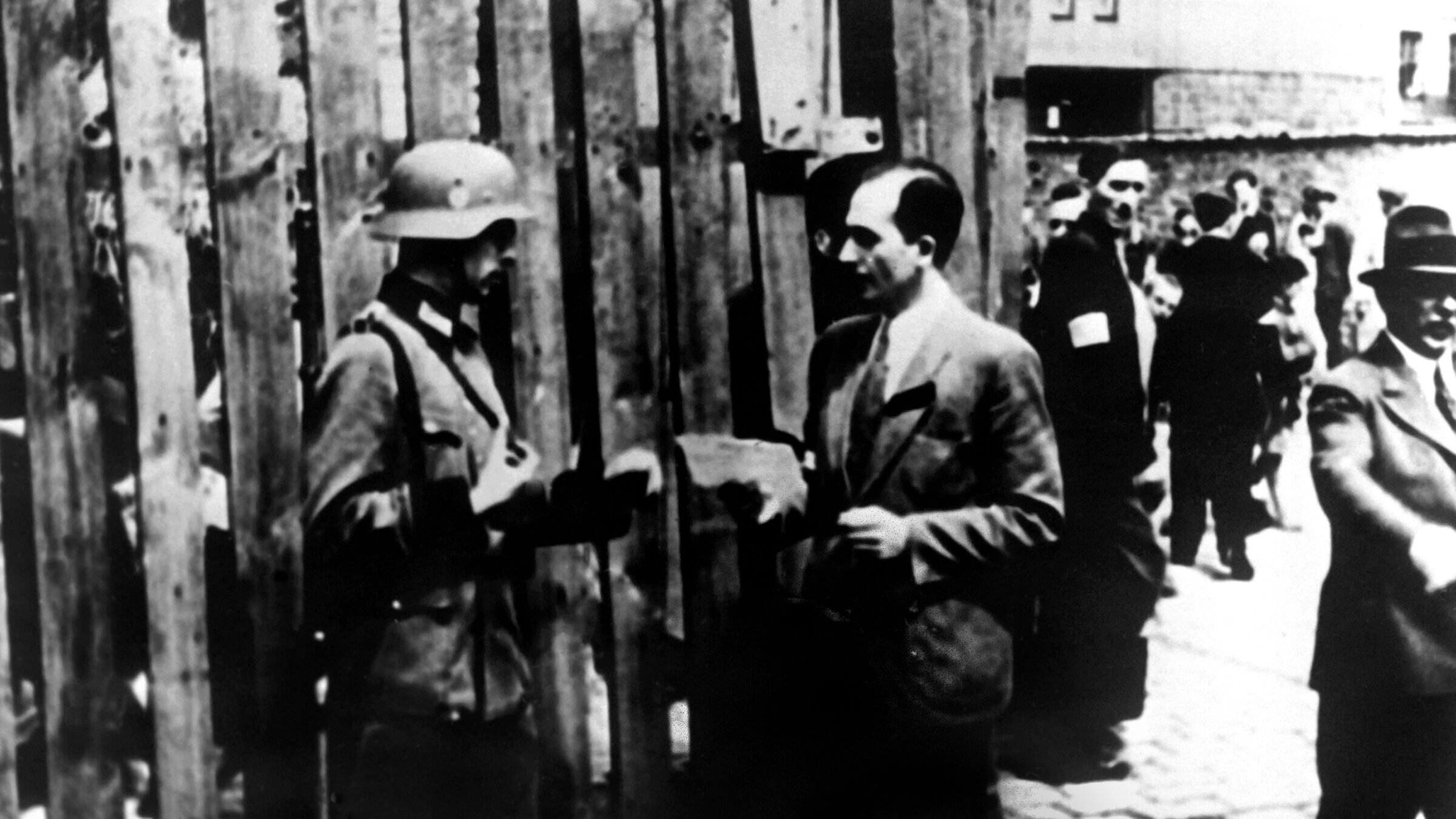 A Nazi soldier checks someone's papers in Warsaw's Jewish ghetto during World War II.