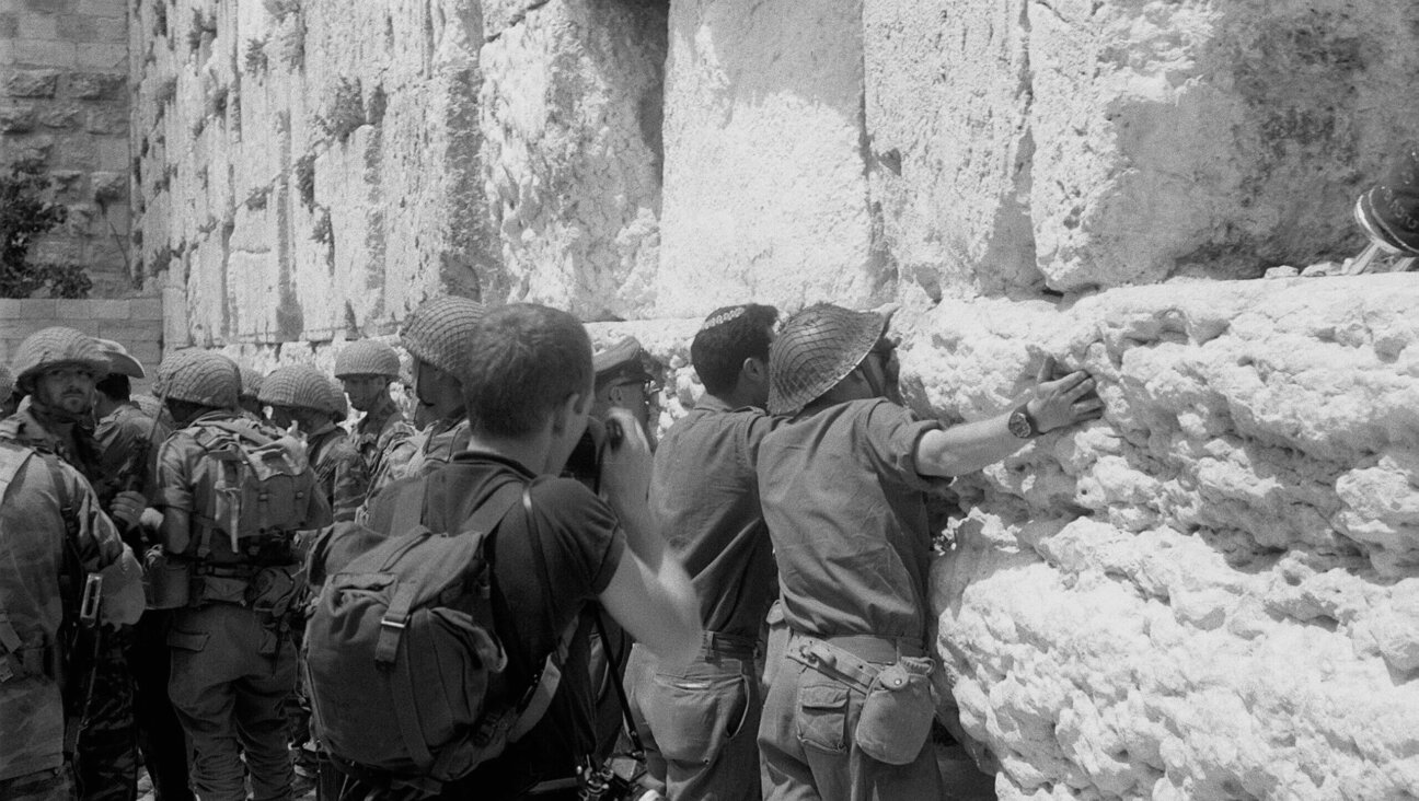 At the end of the Six Day War, Israeli soldiers hug and kiss the stones of the Western Wall.