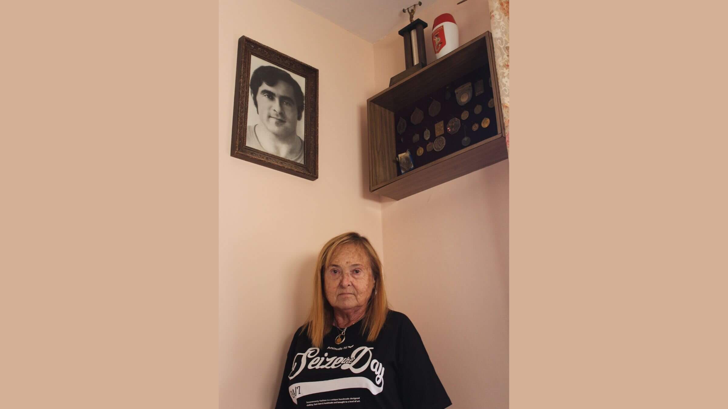 Nina Fridman in area of her apartment with weightlifting trophies earned by her brother Zev. 