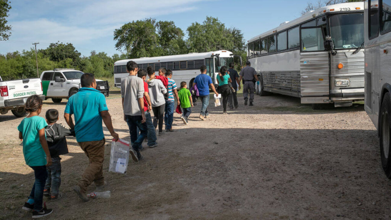 Immigrants walk to U.S. Homeland Security busses to be transferred to a U.S. Border Patrol facility in McAllen after crossing from Mexico on July 02, 2019 in Los Ebanos, Texas. 