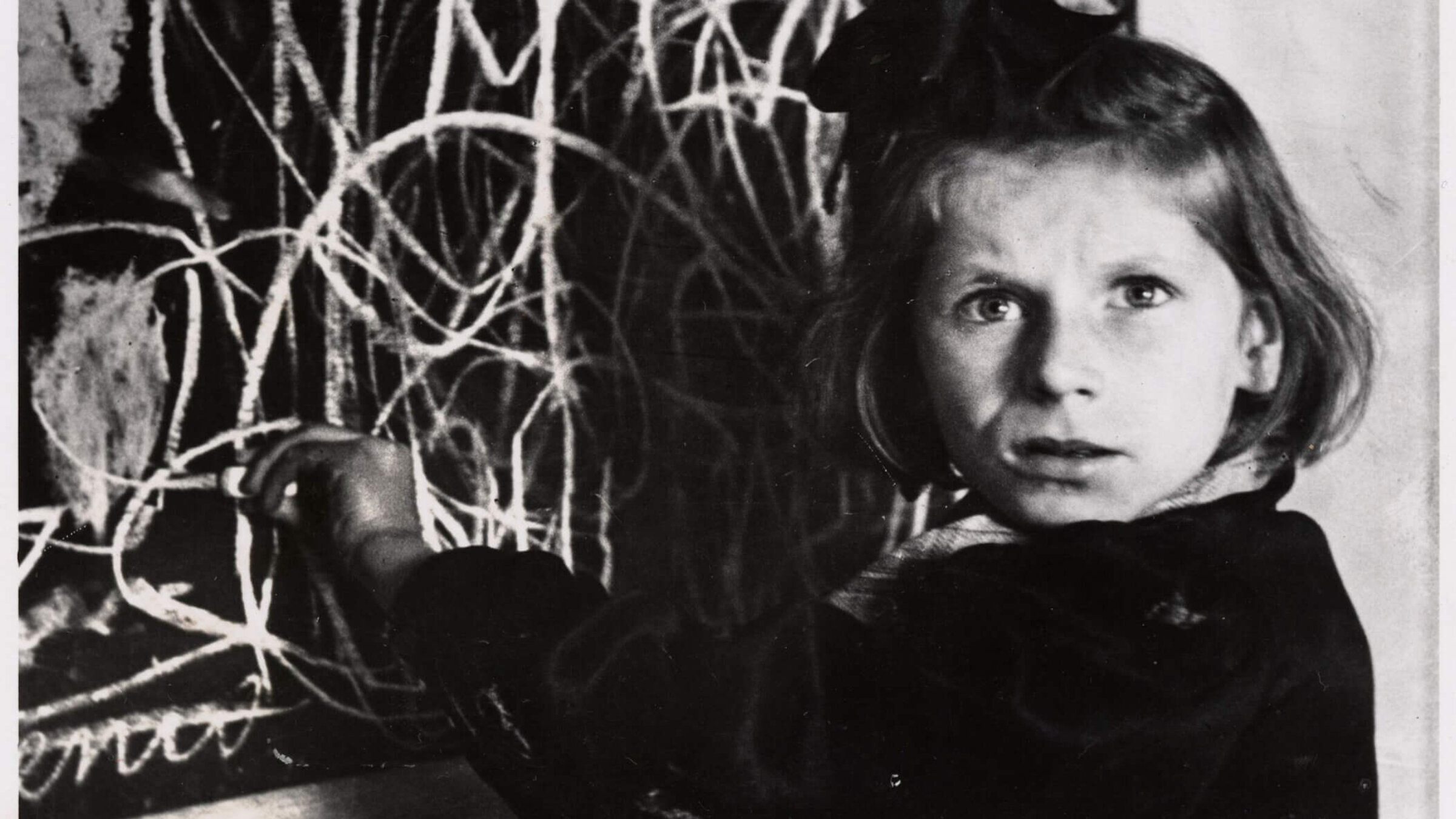 Tereska standing by her drawing of “home” in a home for emotionally disturbed children, in Warsaw, Poland, 1948.