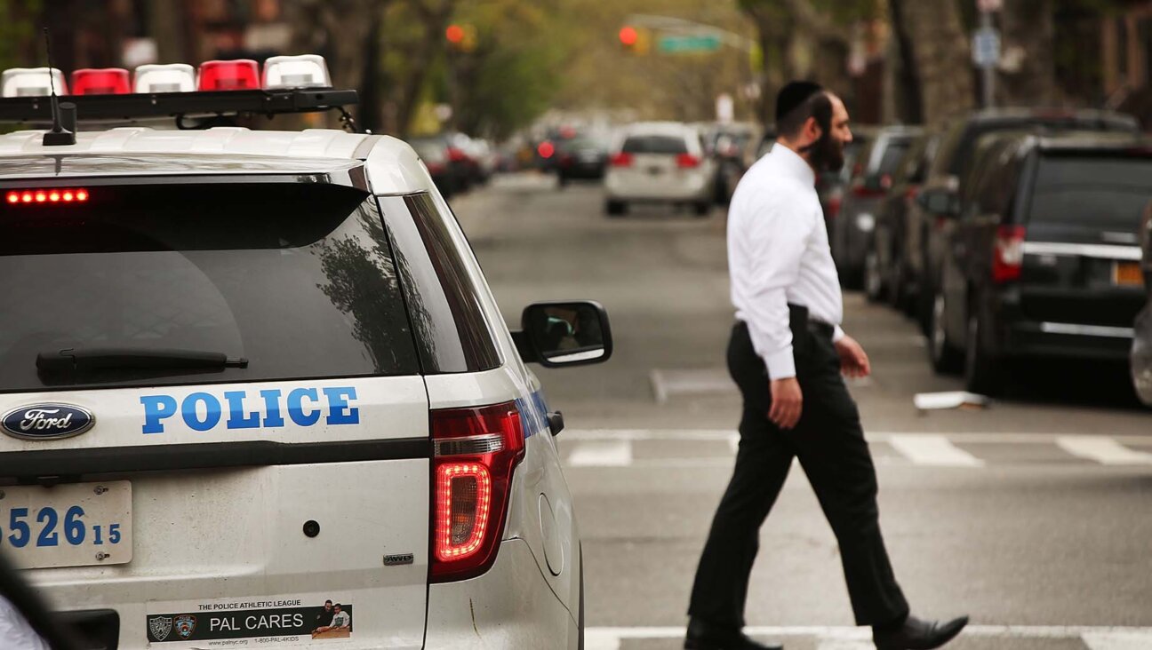 A Hasidic man walks by a police car in a Jewish Orthodox neighborhood in Brooklyn, April 24, 2017. (Spencer Platt/Getty Images)