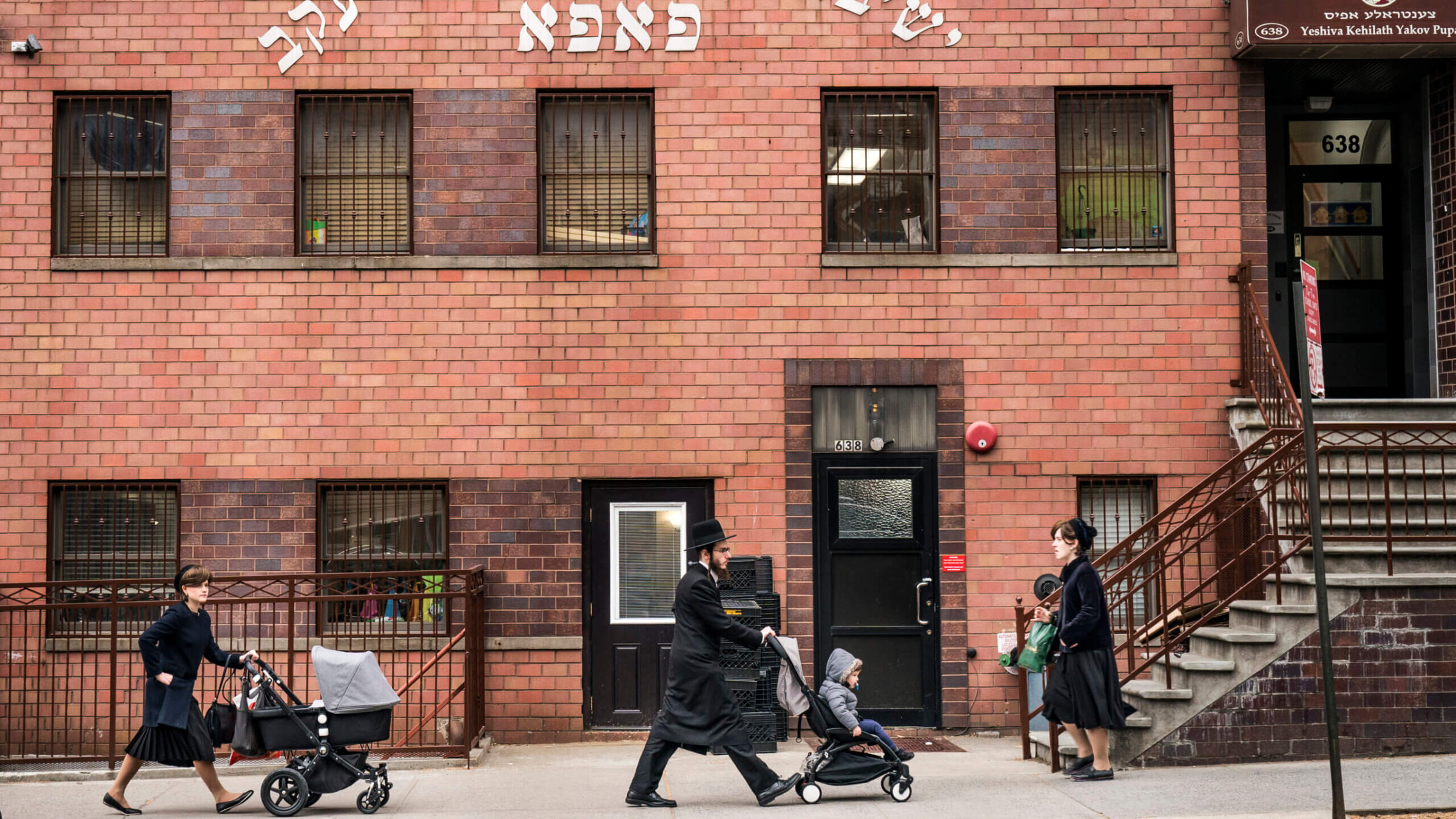 Pedestrians walk past the Yeshiva Kehilath Yakov School in the South Williamsburg neighborhood in the Brooklyn. Hasidic yeshivas, which receive assistance from the UJA-Federation of New York, have been in the spotlight after a state board passed tighter regulations on private schools this week and The New York Times released a scathing investigation critical of some of the yeshivas.