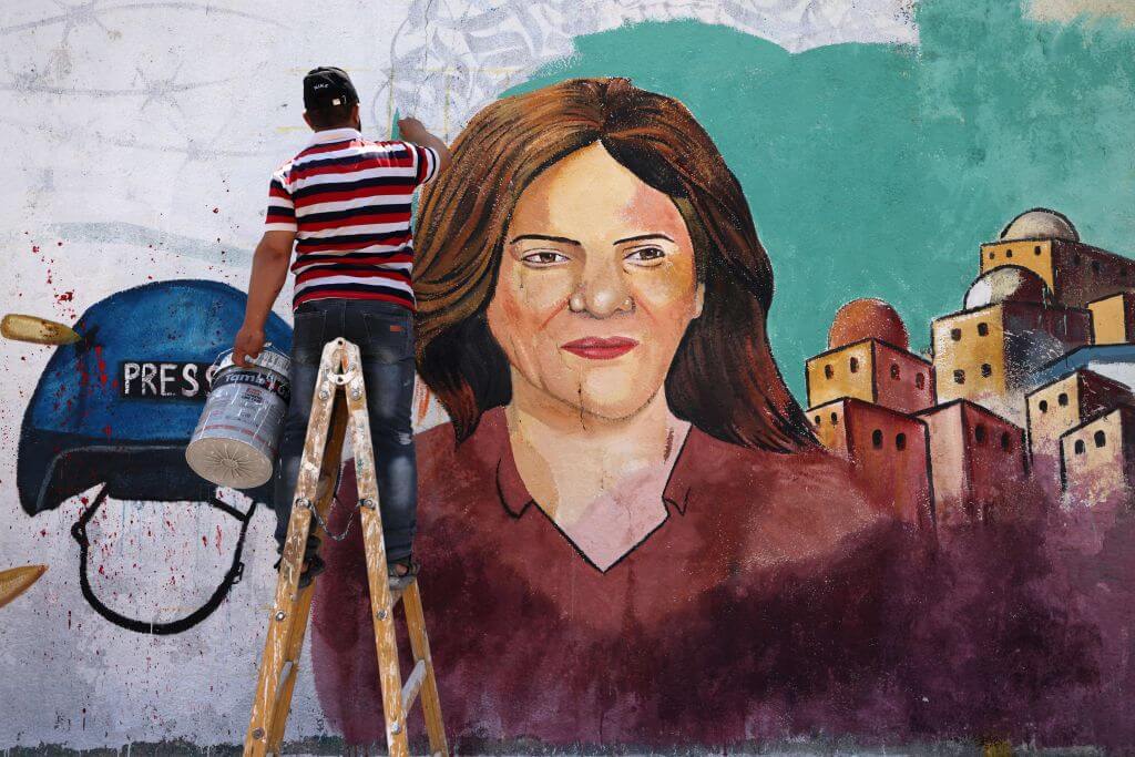 Palestinian artists paint a mural in honor of slain veteran Al-Jazeera journalist Shireen Abu Akleh in Gaza City.