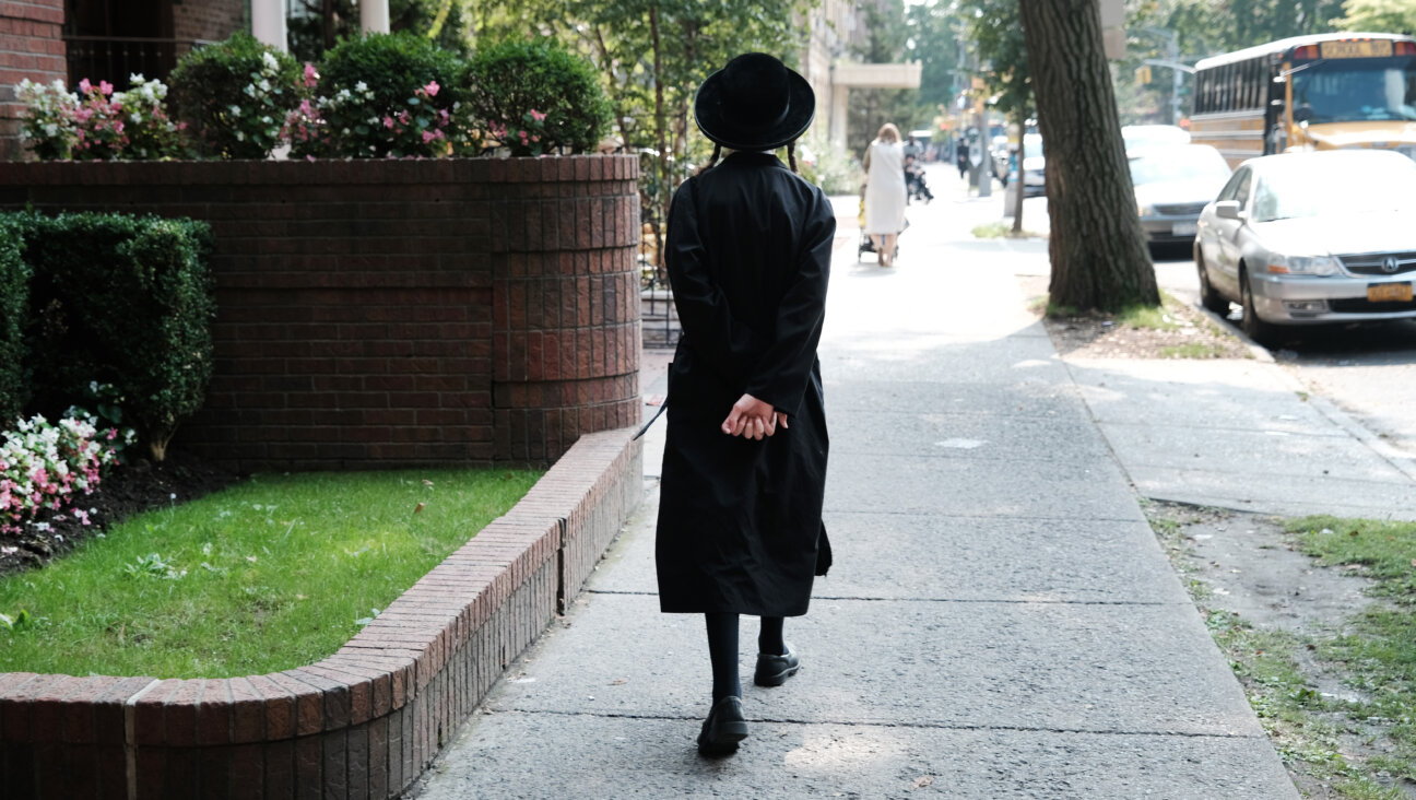 An Orthodox Jewish boy walks down a street outside of a yeshiva school in Borough Park, Brooklyn, on Sept. 12, 2022.